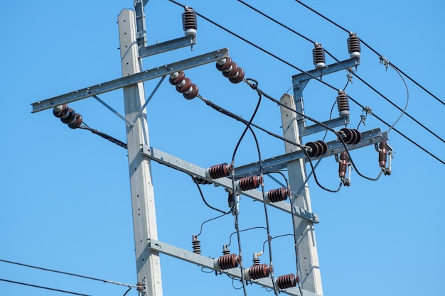 Vista de ângulo baixo de transformador de eletricidade contra um céu azul claro