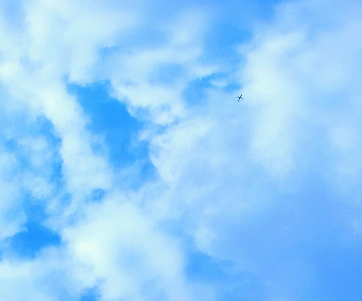 Foto vista de ângulo baixo de um avião voando contra um céu nublado