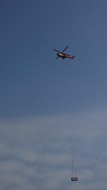 Foto vista de ângulo baixo de um helicóptero voando no céu