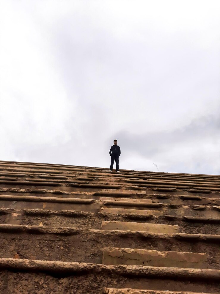 Foto vista de ângulo baixo de um homem de pé na escada contra o céu