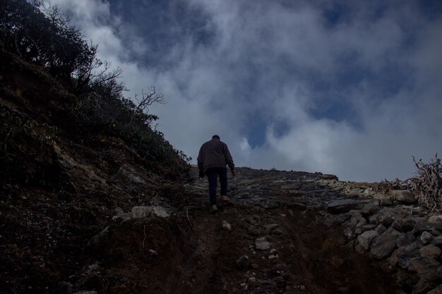 Foto vista de ângulo baixo de um homem escalando uma montanha