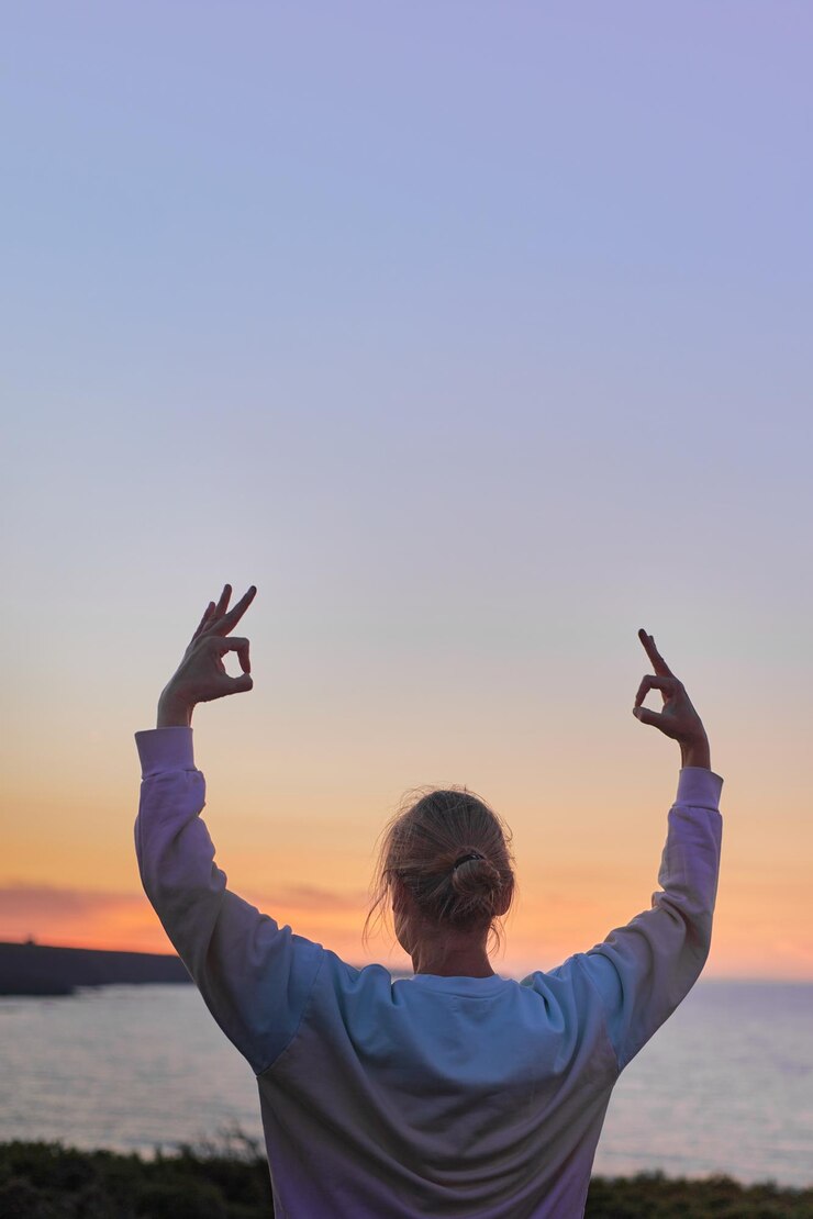 Foto vista de ângulo baixo de um homem fotografando contra um céu claro durante o pôr do sol