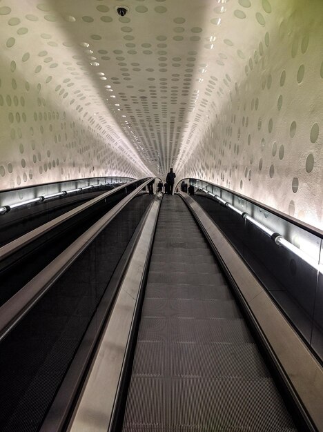 Foto vista de ângulo baixo de um homem na escada rolante