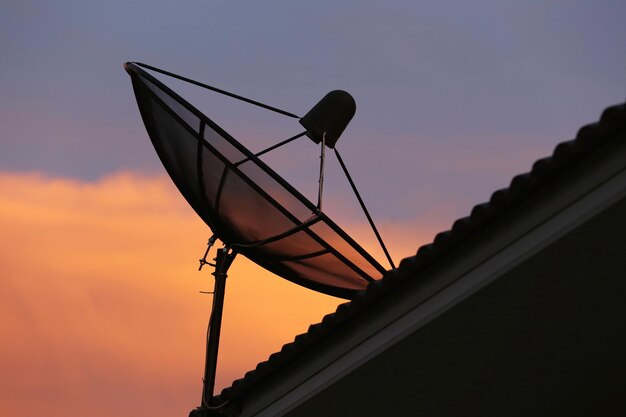 Foto vista de ângulo baixo de um poste de telefone em silhueta contra o céu durante o pôr do sol