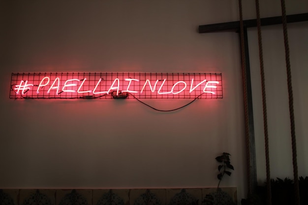 Vista de ângulo baixo de um sinal de informação iluminado na parede à noite