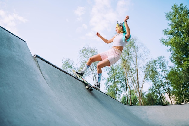 Vista de ângulo baixo de uma mulher skateboarding