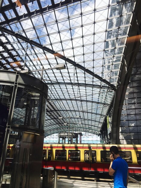 Foto vista de ângulo baixo de uma pessoa de pé na estação ferroviária