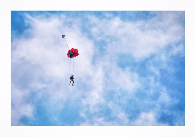 Vista de ângulo baixo de uma pessoa em parapente contra o céu