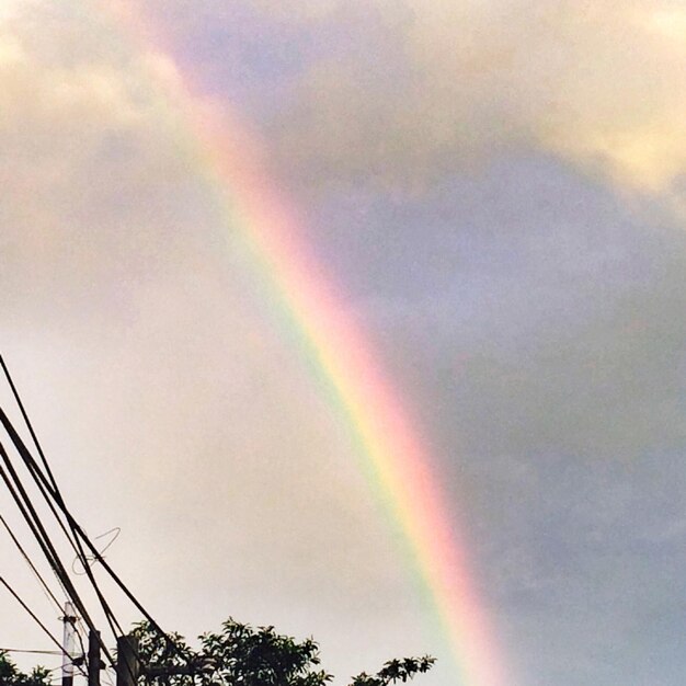 Foto vista de ângulo baixo do arco-íris contra o céu nublado