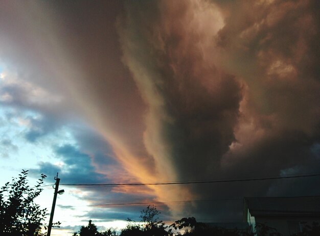 Foto vista de ângulo baixo do arco-íris contra o céu nublado