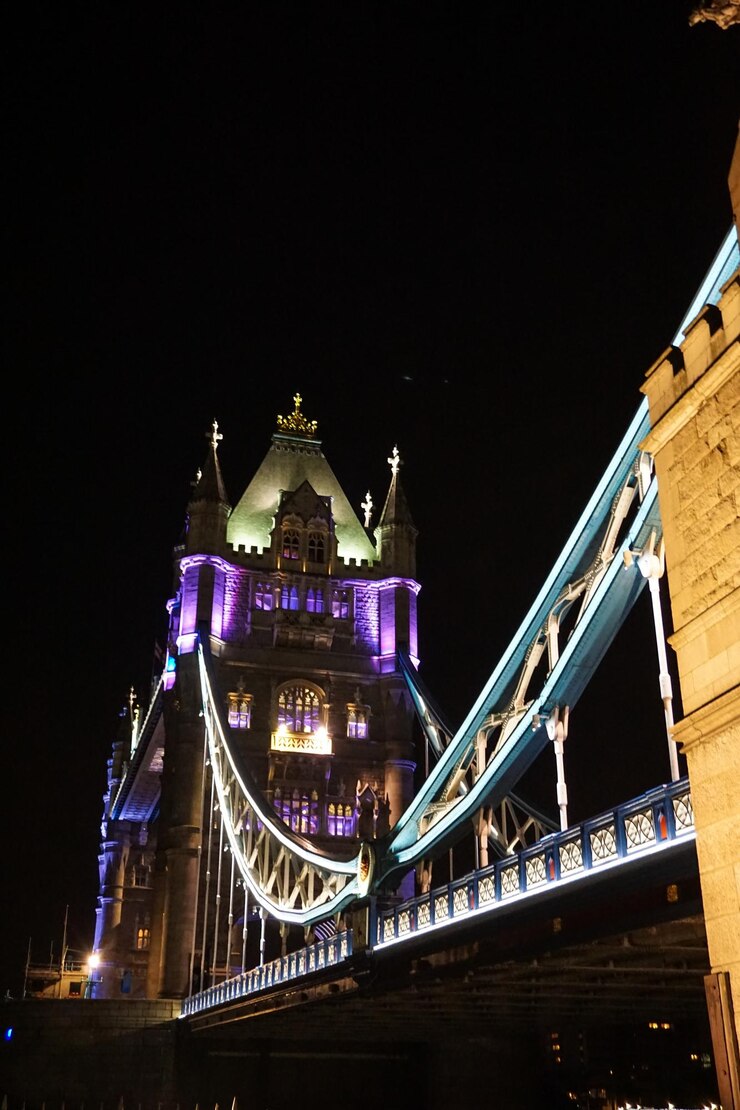 Foto vista de ângulo baixo do céu iluminado da ponte da torre na cidade à noite