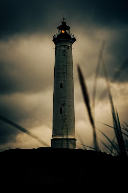 Foto vista de ângulo baixo do farol contra o céu durante o pôr do sol