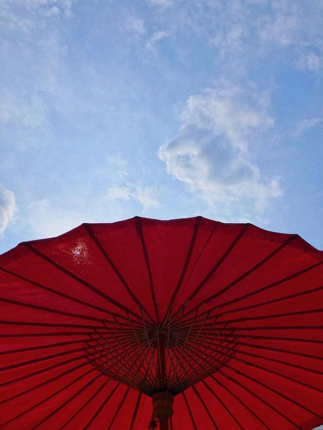 Vista de ângulo baixo do guarda-chuva vermelho contra o céu