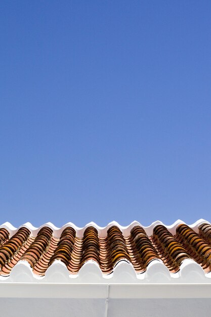 Foto vista de ângulo baixo do telhado contra o céu azul claro