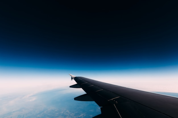 Vista de asa de avião para um espaço misterioso azul