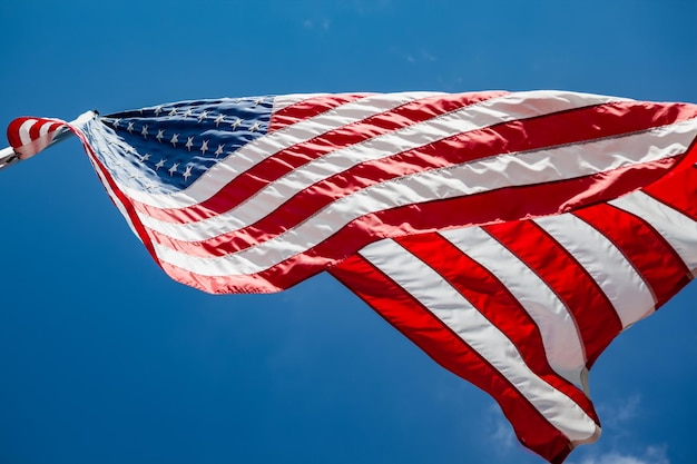 Vista de baixo ângulo da bandeira americana ondulando contra o céu azul