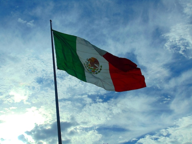 Vista de baixo ângulo da bandeira mexicana contra o céu