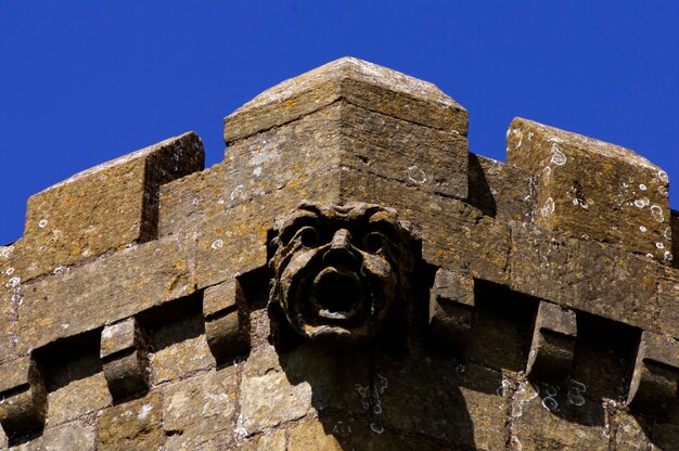 Vista de baixo ângulo da escultura no edifício histórico contra o céu azul