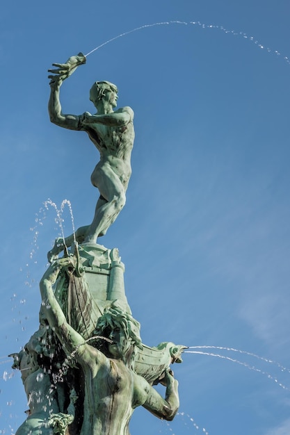 Foto vista de baixo ângulo da estátua de brabo na praça grande markt de antuérpia contra o céu azul