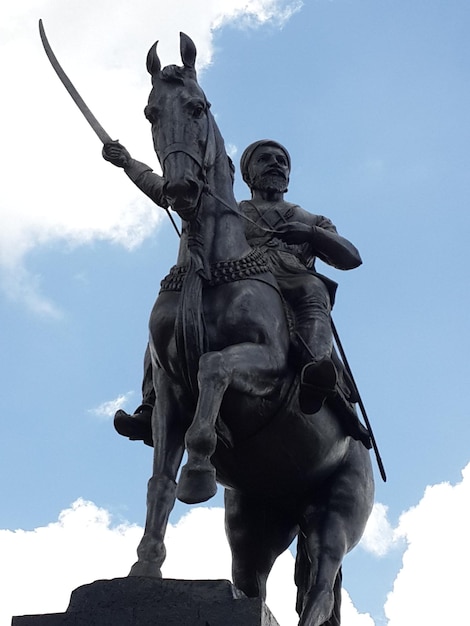 Vista de baixo ângulo da estátua negra de shivaji contra o céu