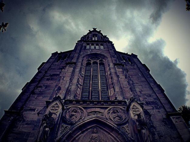 Foto vista de baixo ângulo da igreja contra o céu nublado