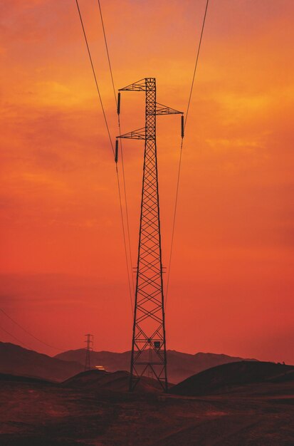 Vista de baixo ângulo da silhueta do pilar de eletricidade contra o céu romântico ao pôr do sol