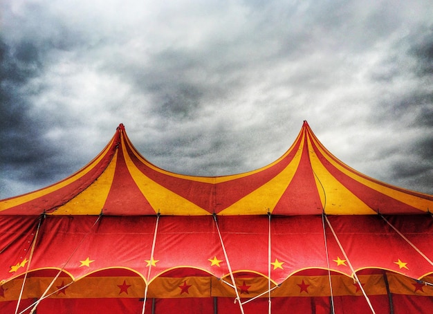 Foto vista de baixo ângulo da tenda de circo contra o céu nublado