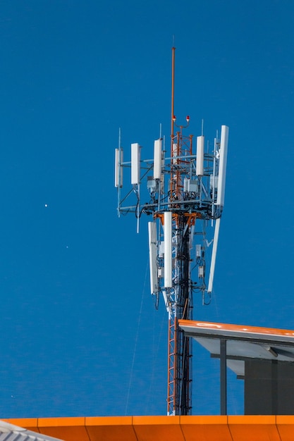 Vista de baixo ângulo da torre de comunicações contra um céu azul claro