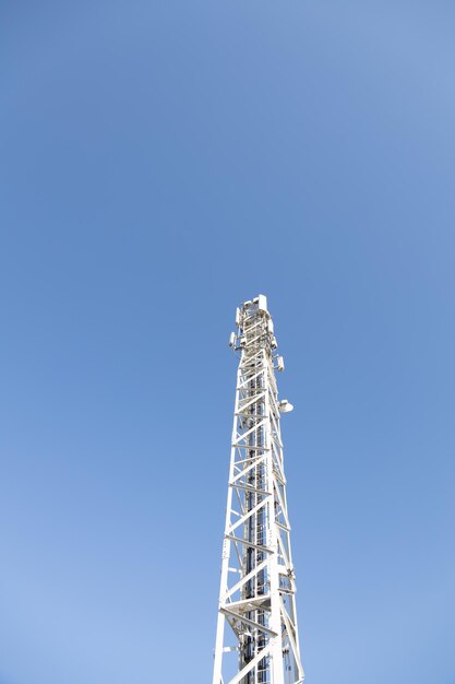 Foto vista de baixo ângulo da torre de comunicações contra um céu azul claro