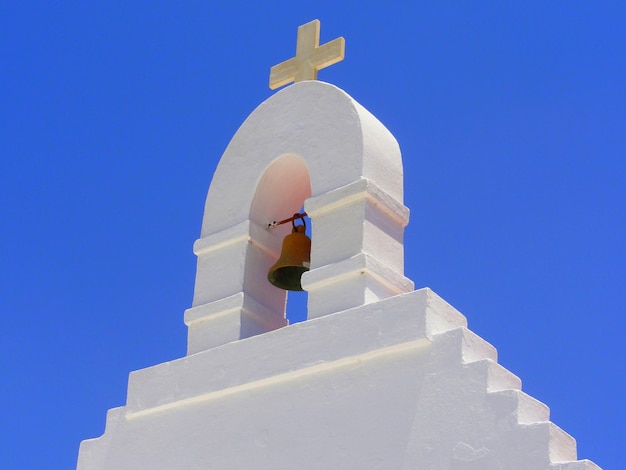 Vista de baixo ângulo da torre do sino contra um céu azul claro em um dia ensolarado