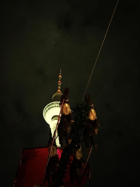 Vista de baixo ângulo da torre iluminada contra o céu à noite