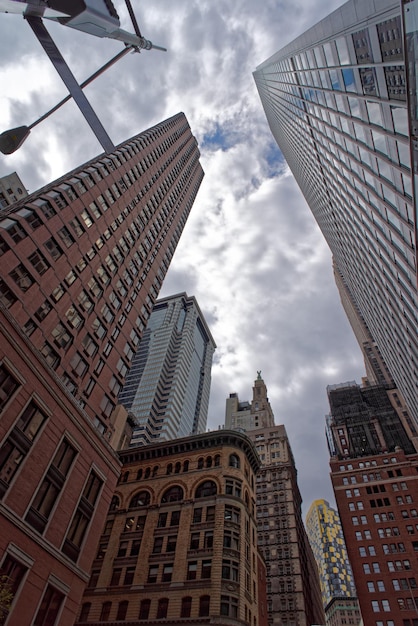 Vista de baixo ângulo de arranha-céus de Nova York. Os arranha-céus da cidade de Nova York estão concentrados em Manhattan, embora outros bairros de Manhattan e os bairros do Brooklyn, Queens também tenham alguns arranha-céus