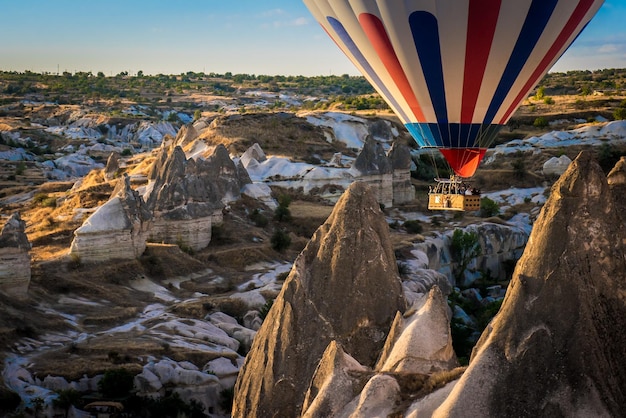 Foto vista de baixo ângulo de balão de ar quente voando sobre montanhas na capadocia