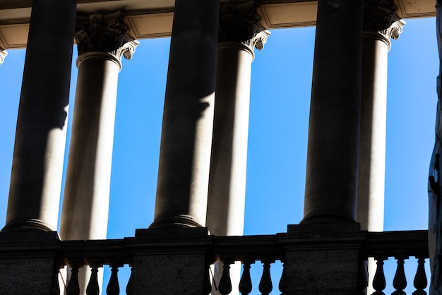 Foto vista de baixo ângulo de colunas em edifício histórico contra um céu azul claro