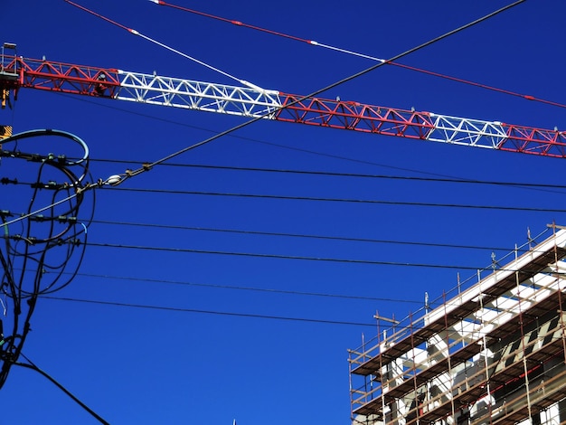 Foto vista de baixo ângulo de linhas elétricas contra o céu azul