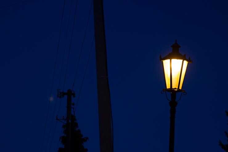 Foto vista de baixo ângulo de luz de rua iluminada contra um céu azul claro