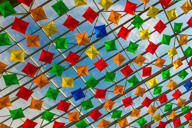 Foto vista de baixo ângulo de têxteis multicoloridos pendurados no teto contra o céu