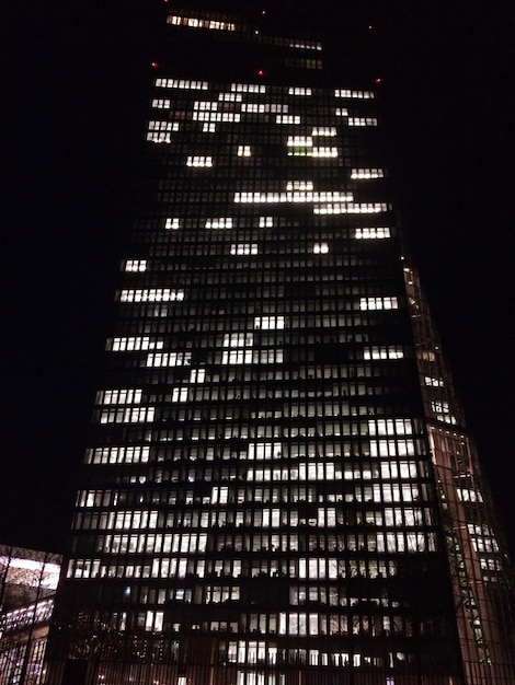 Foto vista de baixo ângulo de um edifício iluminado à noite