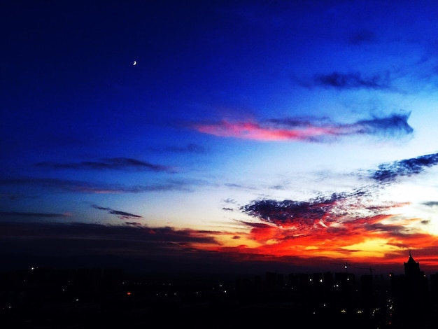 Foto vista de baixo ângulo do céu ao pôr-do-sol sobre a paisagem de silhueta