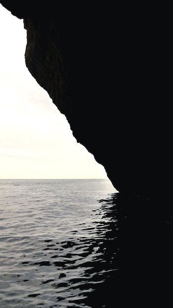 Foto vista de baixo ângulo do penhasco no mar