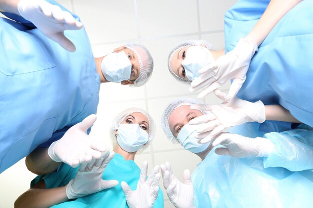 Vista de baixo dos cirurgiões em trajes de trabalho de proteção durante a operação
