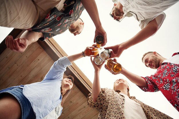 Vista de baixo Grupo de pessoas com cerveja nas mãos a divertir-se