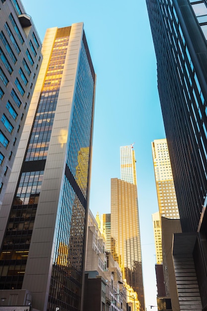 Vista de baixo para cima em arranha-céus de Manhattan que refletem outros arranha-céus através de seu vidro, Nova York, NYC, EUA