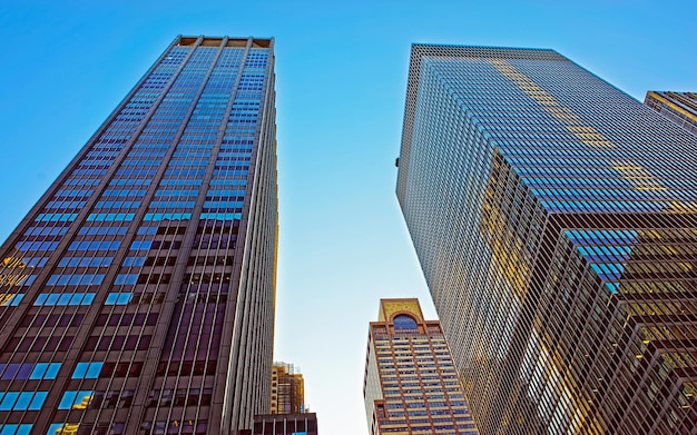 Vista de baixo para cima no distrito financeiro de lower manhattan, nova york, nyc, eua. edifícios de vidro altos dos arranha-céus estados unidos da américa. céu azul no fundo. lugar vazio para espaço de cópia.