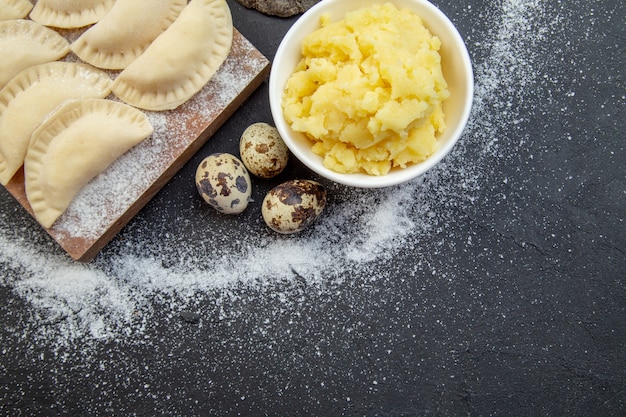 vista de cima bolinhos quentes crus com farinha de batata e ovos em fundo escuro torta asse cozinhando biscoito bolo comida