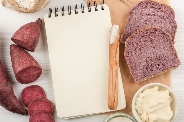 Vista de cima Composição da Fatia de Pão Roxo Caseiro Feito de Batata Doce Japonesa Roxa com Cor natural. Conceito de Padaria com Dieta Saudável, Copie o Espaço para Texto ou Receita no Fundo Branco