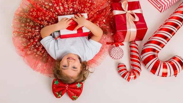 Vista de cima, criança cercada por elementos de natal