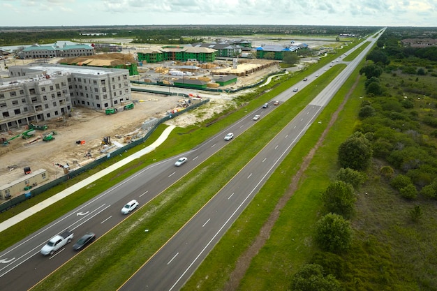 Vista de cima da estrutura inacabada de condomínios de apartamentos com vigas de telhado de madeira em construção Desenvolvimento de habitação residencial perto da rodovia estadual nos subúrbios dos EUA Mercado imobiliário nos EUA