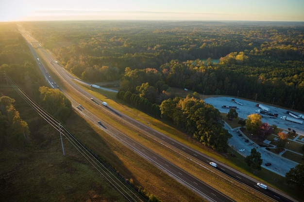 Vista de cima da grande área de estacionamento para carros e caminhões perto da movimentada rodovia americana com tráfego rápido Local recreativo durante viagens interestaduais