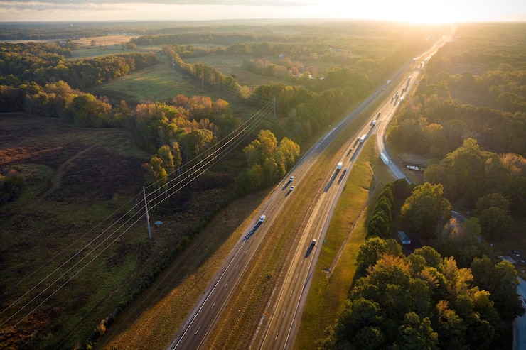Foto vista de cima da movimentada rodovia americana com tráfego rápido entre bosques de outono conceito de transporte interestadual